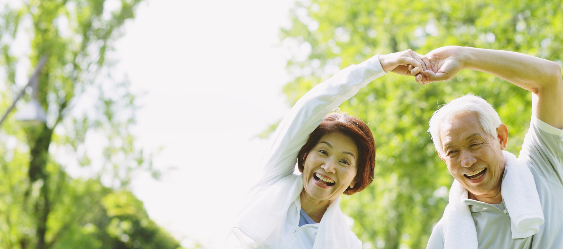 老夫婦が笑顔で手を取り合い体操している